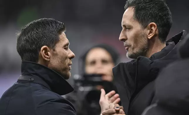 Frankfurt's head coach Dino Toppmoeller, right, and Leverkusen's head coach Xabi Alonso, left, greet each other before the German Bundesliga soccer match between Eintracht Frankfurt and Bayer Leverkusen in Frankfurt, Germany, Saturday, March 1, 2025. (Arne Dedert/dpa via AP)