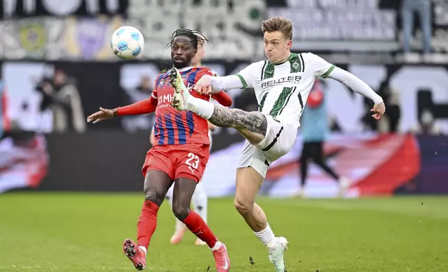 Heidenheim's Omar Traore, left, and Moenchengladbach's Luca Netz, right, challenge for the ball during the German Bundesliga soccer match between 1. FC Heidenheim and Borussia Moenchengladbach in Heidenheim, Germany, Saturday, March 1, 2025. (Harry Langer/dpa via AP)