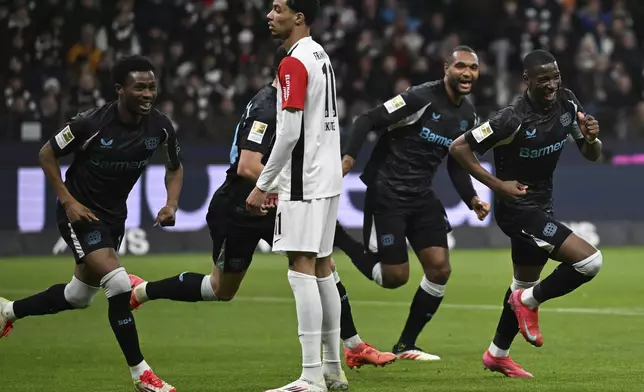 Leverkusen's scorer Nordi Mukiele, right, and his teammates celebrate their side's second goal during the German Bundesliga soccer match between Eintracht Frankfurt and Bayer Leverkusen in Frankfurt, Germany, Saturday, March 1, 2025. (Arne Dedert/dpa via AP)