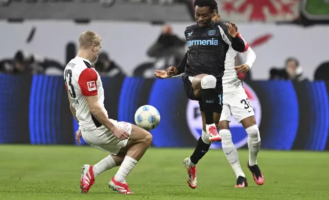 Frankfurt's Rasmus Kristensen, left, and Leverkusen's Nathan Tella, right, challenge for the ball during the German Bundesliga soccer match between Eintracht Frankfurt and Bayer Leverkusen in Frankfurt, Germany, Saturday, March 1, 2025. (Arne Dedert/dpa via AP)