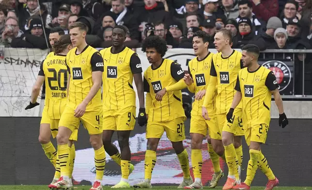 Dortmund's Serhou Guirassy, fifth right, celebrates with his teammates after scoring the opening goal during the German Bundesliga soccer match between FC St. Pauli and Borussia Dortmund in Hamburg, Germany, Saturday, March 1, 2025. (Marcus Brandt/dpa via AP)