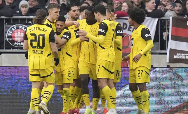 Dortmund's Serhou Guirassy, fifth left, celebrates with his teammates after scoring the opening goal during the German Bundesliga soccer match between FC St. Pauli and Borussia Dortmund in Hamburg, Germany, Saturday, March 1, 2025. (Marcus Brandt/dpa via AP)