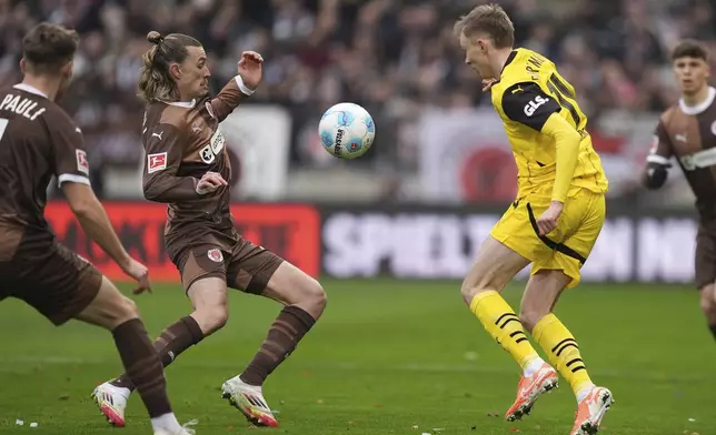 St. Pauli's Jackson Irvine, left, and Dortmund's Maximilian Beier, right, challenge for the ball during the German Bundesliga soccer match between FC St. Pauli and Borussia Dortmund in Hamburg, Germany, Saturday, March 1, 2025. (Marcus Brandt/dpa via AP)
