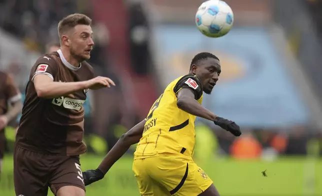 St. Pauli's Hauke Wahl, left, and Dortmund's Serhou Guirassy, right, challenge for the ball during the German Bundesliga soccer match between FC St. Pauli and Borussia Dortmund in Hamburg, Germany, Saturday, March 1, 2025. (Marcus Brandt/dpa via AP)
