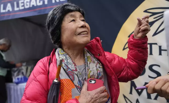 Masako Higuchi, 83, gathers with other runners ahead of the Los Angeles Marathon at the Lifestyle Expo at Dodger Stadium, Friday, March 14, 2025 in Los Angeles. (AP Photo/Damian Dovarganes)