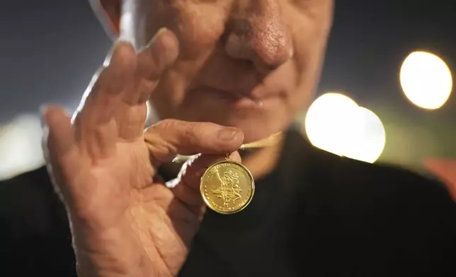 Cliff Housego shows a participatory medal for LA Marathon before the race Sunday, March 16, 2025, in Los Angeles. (AP Photo/Eric Thayer)