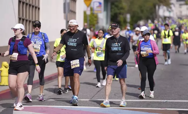 Cliff Housego, center right, and Lou Briones, center left, participate in the LA Marathon before the race Sunday, March 16, 2025, in Los Angeles. (AP Photo/Eric Thayer)