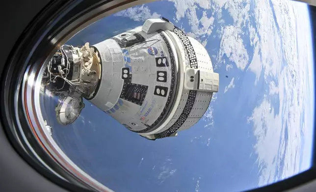FILE - This photo provided by NASA shows Boeing's Starliner spacecraft, which launched astronauts Butch Wilmore and Suni Williams to the International Space Station, docked to the Harmony module's forward port on July 3, 2024, seen from a window on the SpaceX Dragon Endeavour spacecraft docked to the adjacent port. (NASA via AP, File)