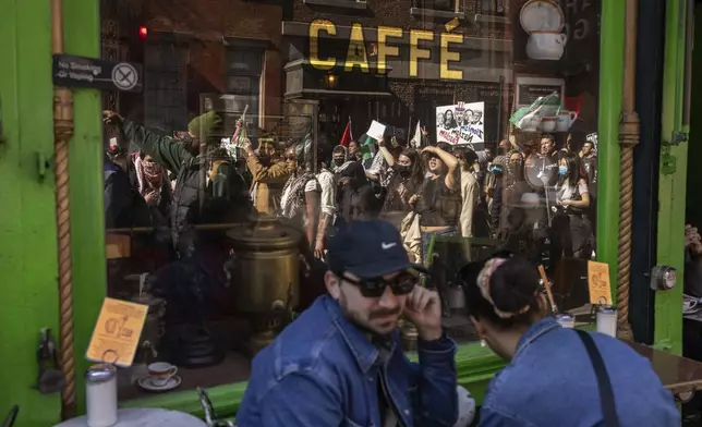 A reflection on the window shows protesters marching during a demonstration in support of Palestinian activist Mahmoud Khalil, Tuesday, March 11, 2025, in New York. (AP Photo/Yuki Iwamura)