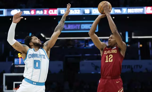 Cleveland Cavaliers forward De'Andre Hunter (12) shoots over Charlotte Hornets forward Miles Bridges (0) during the first half of an NBA basketball game in Charlotte, N.C., Friday, March 7, 2025. (AP Photo/Nell Redmond)