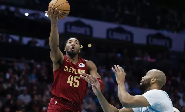 Cleveland Cavaliers guard Donovan Mitchell (45) drives to the basket against Charlotte Hornets forward Taj Gibson, right, during the first half of an NBA basketball game in Charlotte, N.C., Friday, March 7, 2025. (AP Photo/Nell Redmond)