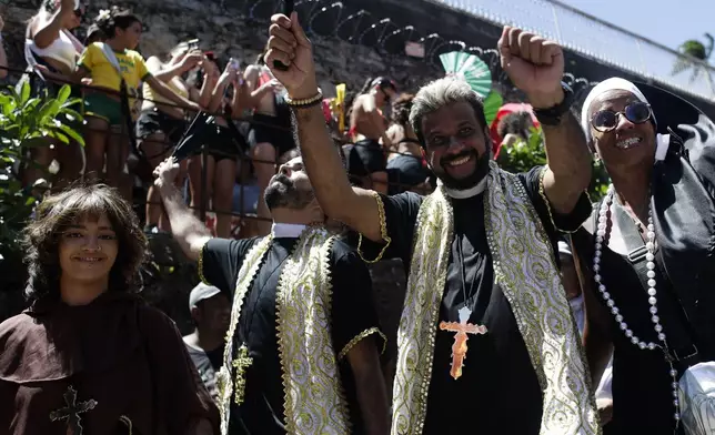 Revelers dressed as priests dance during the Carmelitas street party on the first official day of Carnival in Rio de Janeiro, Friday, Feb. 28, 2025. (AP Photo/Bruna Prado)