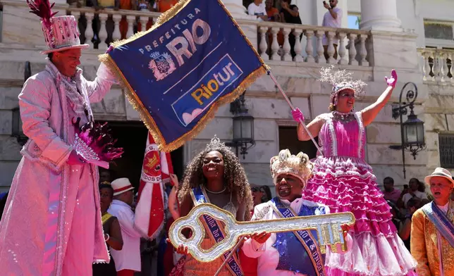 Carnival King Momo, Kaio Mackenzie, front right, and Queen Thuane de Oliveira, hold the keys of the city at a ceremony that officially kicks off Carnival in Rio de Janeiro, Brazil, Friday, Feb. 28, 2025. (AP Photo/Silvia Izquierdo)