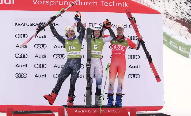 Norway's Henrik Kristoffersen, center ,winner of an alpine ski, men's World Cup giant slalom, celebrates on the podium with second-placed Brazil's Lucas Pinheiro Braathen, left, and third-placed Switzerland's Marco Odermatt, in Kranjska Gora, Slovenia, Saturday, March 1, 2025. (AP Photo/Giovanni Auletta)
