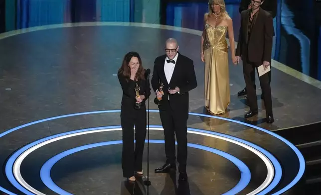 Shirin Sohani, left, and Hossein Molayemi accept the award for best animated short for "In the Shadow of the Cypress" during the Oscars on Sunday, March 2, 2025, at the Dolby Theatre in Los Angeles. Goldie Hawn, second right, and Andrew Garfield look on from right. (AP Photo/Chris Pizzello)