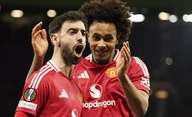 Manchester United's Bruno Fernandes left, and Manchester United's Joshua Zirkzee celebrate scoring their side's first goal during the Europa League soccer match between Manchester United and Real Sociedad at Old Trafford stadium in Manchester, England, Thursday, March 13, 2025 . (AP Photo/Dave Thompson)