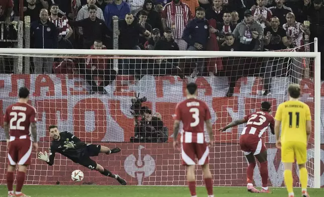Glimt's goalkeeper Nikita Haikin saves a ball from a penalty of Olympiacos' Rodinei, second left, during the Europa League round of 16 second leg soccer match between Olympiacos FC and FK Bodo/Glimt at the Georgios Karaiskakis stadium at Athens' port of Piraeus, Greece, Thursday, March 13, 2025. (AP Photo/Thanassis Stavrakis)