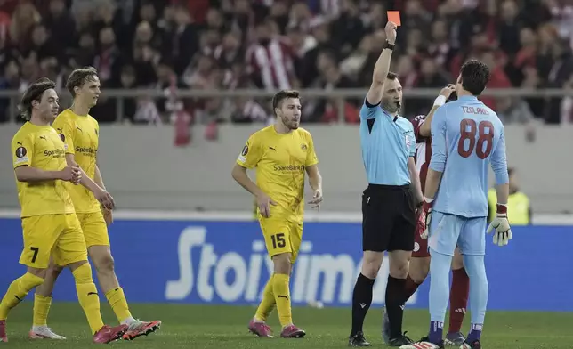 Olympiacos' goalkeeper Konstantinos Tzolakis is shown the red card from the referee Felix Zwayer during the Europa League round of 16 second leg soccer match between Olympiacos FC and FK Bodo/Glimt at the Georgios Karaiskakis stadium at Athens' port of Piraeus, Greece, Thursday, March 13, 2025. (AP Photo/Thanassis Stavrakis)