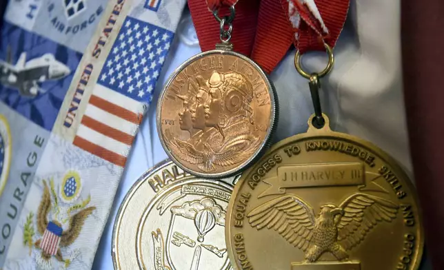 Medals are draped around the neck of 101-year-old Col. James H. Harvey III, one of the last surviving Tuskegee Airmen, at the Veterans Community Living Center in Aurora, Colo., Wednesday, March 12, 2025. (AP Photo/Thomas Peipert)