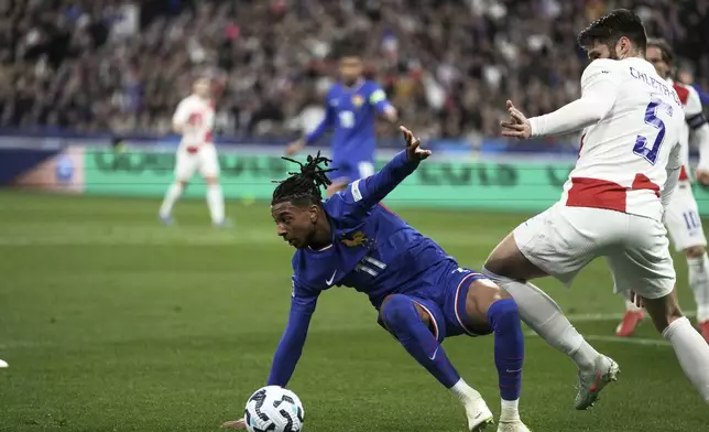 France's Michael Olise, left, and Croatia's Duje Caleta-Car vie for the ball during the UEFA Nations League quarterfinal second leg soccer match between France and Croatia, at the Stade de France in Saint-Denis, outside Paris, Sunday, March 23, 2025. (AP Photo/Thibault Camus)