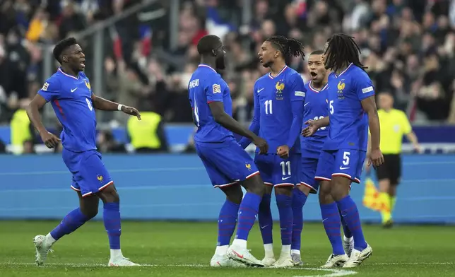 France's Michael Olise (11) is congratulated after scoring his side's opening goal during the UEFA Nations League quarterfinal second leg soccer match between France and Croatia, at the Stade de France in Saint-Denis, outside Paris, Sunday, March 23, 2025. (AP Photo/Thibault Camus)