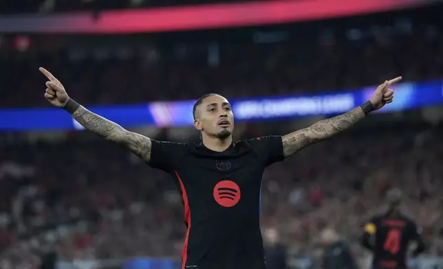 Barcelona's Raphinha celebrates after scoring his side's opening goal during the Champions League round of 16 first leg soccer match between SL Benfica and FC Barcelona at the Luz stadium in Lisbon, Wednesday, March 5, 2025. (AP Photo/Armando Franca)