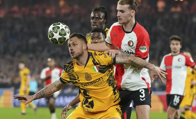 Inter Milan's Marko Arnautovic, front , and Feyenoord's Thomas Beelen fight for the ball during the Champions League round of 16 first leg soccer match between Feyenoord and Inter Milan in Rotterdam, Netherlands, Wednesday, March 5, 2025. (AP Photo/Peter Dejong)