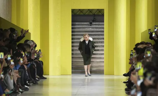 Designer Miuccia Prada accepts applause after the Miu Miu Fall/Winter 2025-2026 Womenswear collection presented Tuesday, March 11, 2025. in Paris. (Photo by Scott A Garfitt/Invision/AP)