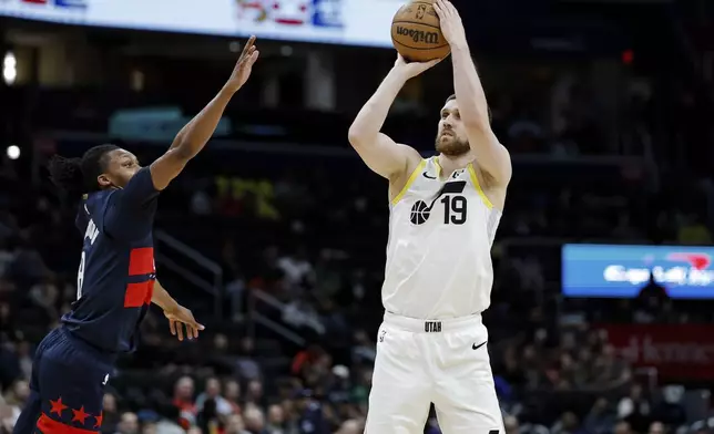 Utah Jazz guard Svi Mykhailiuk (19) shoots the ball as Washington Wizards guard Bub Carrington defends during the first half of an NBA basketball game, Wednesday, Mar. 5, 2025, in Washington. (AP Photo/Terrance Williams)