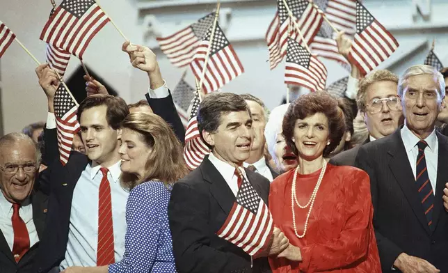 FILE - Gov Michael Dukakis and his wife Kitty wave the American flag as they are cheered by delegates after Dukakis accepted the nomination as the presidential candidate in July 21, 1988 at the Democratic National Convention in Atlanta. (AP Photo/Charles Tasnadi, File)