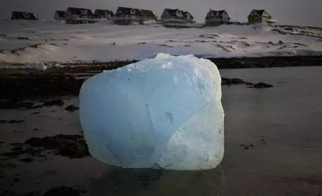 A piece of ice is photographed melting at the shore of a beach in Nuuk, Greenland, Friday, Feb. 14, 2025. (AP Photo/Emilio Morenatti)