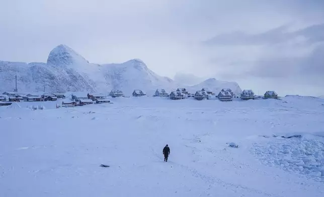 A woman walks on a beach in Nuuk, Greenland, March 4, 2025. (AP Photo/Evgeniy Maloletka)
