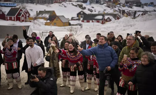 Relatives and family members throw rice at Salik and Malu Schmidt as they leave the church of our Savior after getting married in Nuuk, Greenland, Saturday, Feb. 15, 2025. (AP Photo/Emilio Morenatti)