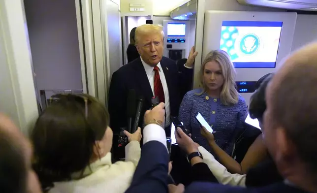 FILE - President Donald Trump speaks to reporters aboard Air Force One en route from Miami to Joint Base Andrews, Md., Jan. 27, 2025, as White House press secretary Karoline Leavitt listens. (AP Photo/Mark Schiefelbein, File)