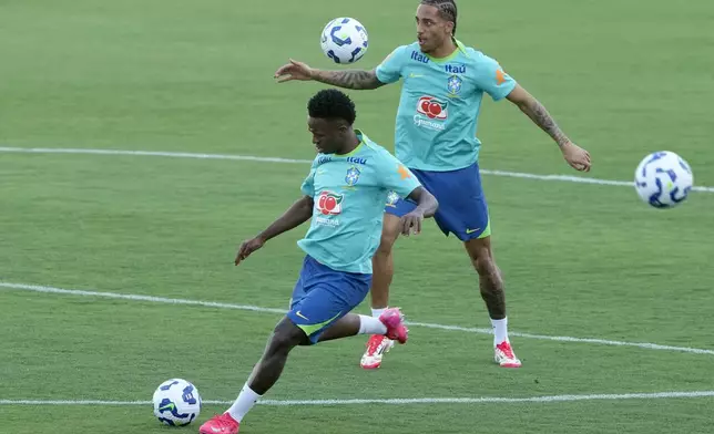 Brazil's Vinicius Junior boots the ball in front of Joao Pedro during a national soccer team training session, in Brasilia, Brazil, Tuesday, March 18, 2025. (AP Photo/Eraldo Peres)