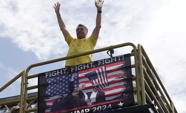 Brazil's former President Jair Bolsonaro gestures to the crowd upon arriving at a rally on Copacabana Beach in support of a proposed bill to grant amnesty to those arrested for storming government buildings in an alleged coup attempt in 2023, in Rio de Janeiro, Sunday, March 16, 2025. (AP Photo/Bruna Prado)