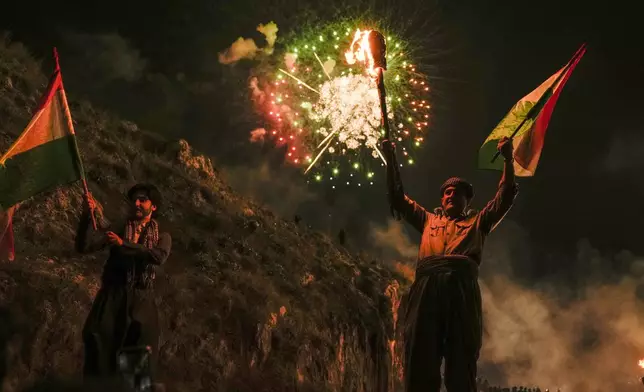 Iraqi Kurds walk up a mountain during a procession to celebrate their Nowruz, the Persian New Year, Akra, in Iraq's northern autonomous Kurdish region, Thursday, March 20, 2025. (AP Photo/Hadi Mizban)