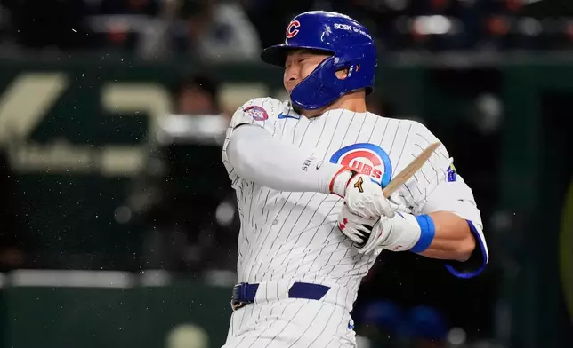 Chicago Cubs' Seiya Suzuki holds on to his broken bat after grounding out in the first inning of an MLB Japan Series baseball game against the Los Angeles Dodgers in Tokyo, Japan, Tuesday, March 18, 2025. (AP Photo/Eugene Hoshiko)