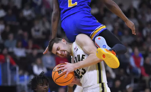 Purdue forward Camden Heide (23) hangs onto the ball while colliding with McNeese State guard DJ Richards Jr. (2) during the first half in the second round of the NCAA college basketball tournament, Saturday, March 22, 2025, in Providence, R.I. (AP Photo/Steven Senne)