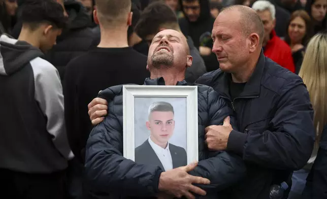 Dragi Stojanov cries holding a photograph of his son Tomche Stojanov, one of the victims of a massive nightclub fire, during a vigil joined by hundreds in the town of Kocani, North Macedonia, Monday, March 17, 2025. (AP Photo/Armin Durgut)