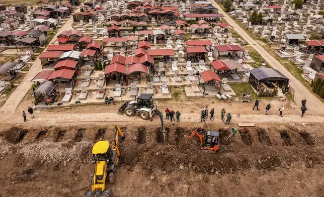 Graves for the victims of a massive nightclub fire are dug with excavators in a cemetery in the town of Kocani, North Macedonia, Tuesday, March 18, 2025. (AP Photo/Armin Durgut)