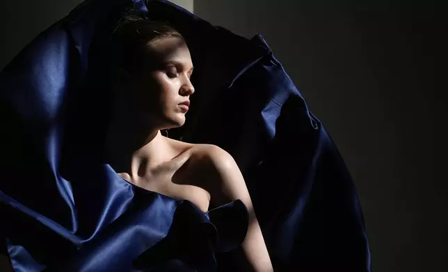 A model sunbathes backstage at Moscow Fashion Week in Moscow, Russia, Tuesday, March 18, 2025. (AP Photo/Pavel Bednyakov)