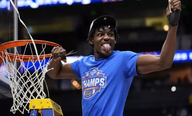 Florida center Rueben Chinyelu (9) cunte part of the net to celebrate victory over Tennessee after an NCAA college basketball game in the final round of the Southeastern Conference tournament, Sunday, March 16, 2025, in Nashville, Tenn. (AP Photo/George Walker IV)