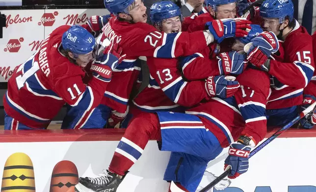 Montreal Canadiens' Josh Anderson (17) gets mobbed by by teammates on the bench after his empty net goal during the third period of an NHL hockey game against the Ottawa Senators, in Montreal on Tuesday, March 18, 2025. (Christinne Muschi/The Canadian Press via AP)