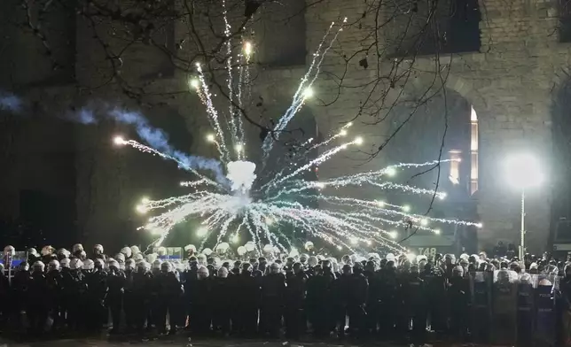 Fireworks thrown by protesters explode over riot police during a protest against the arrest of Istanbul's Mayor Ekrem Imamoglu, in Istanbul, Turkey, Saturday, March 22, 2025. (AP Photo/Khalil Hamra)