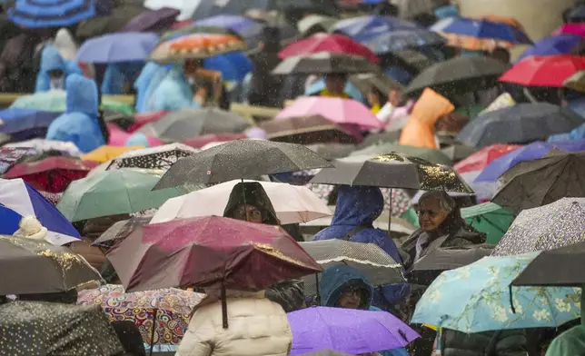 Participants in a mass for the jubilar pilgrims from Naples wait for the start of the celebration under pouring rain in St. Peter's Square at The Vatican, Saturday, March 22, 2025. (AP Photo/Andrew Medichini)