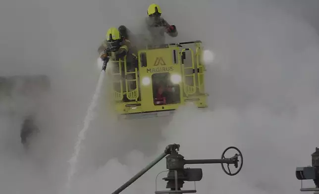 Firefighters extinguish the fire at the North Hyde electrical substation, which caught fire Thursday night and lead to a closure of Heathrow Airport in London, Friday, March 21, 2025.(AP Photo/Kirsty Wigglesworth)