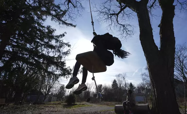 A child rides a tree swing in Detroit, Friday, March 21, 2025. (AP Photo/Paul Sancya)