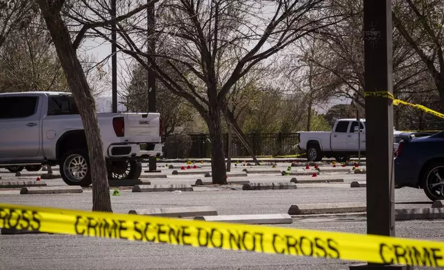 Evidence markers are shown in the parking lot at Young Park after Friday night's fatal shooting in Las Cruces, N.M., on Saturday, March 22, 2025. (Chancey Bush/The Albuquerque Journal via AP)