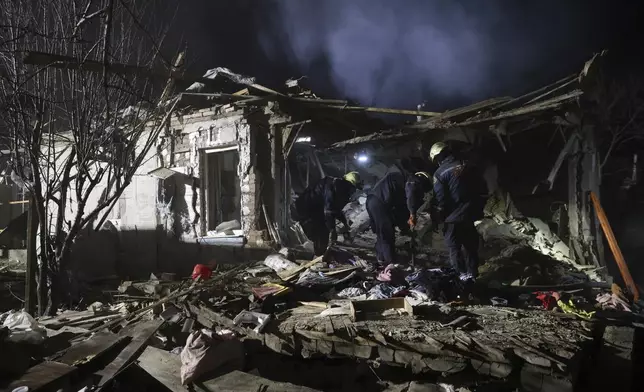 Rescue workers clear the rubble of a residential house destroyed by a Russian drone strike in Zaporizhzhia, Ukraine, Friday, March 21, 2024. (AP Photo/Kateryna Klochko)